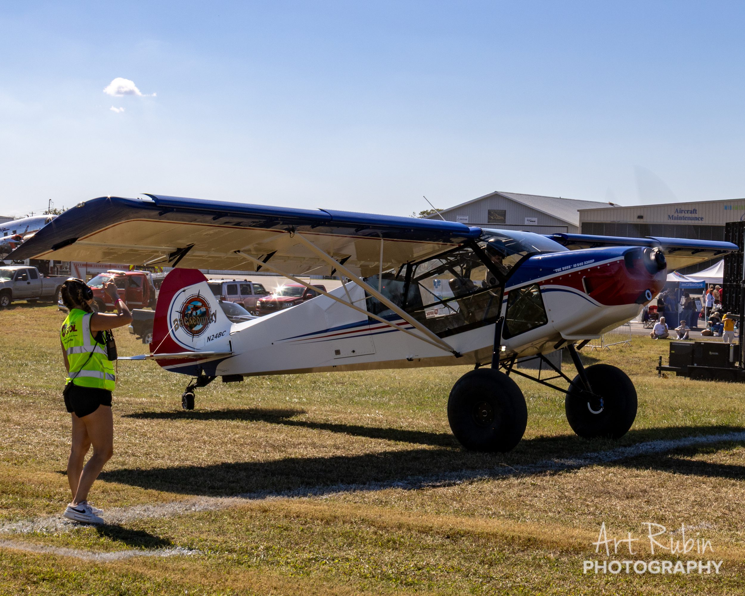 A volunteer line judge alongside a competitor's aircraft