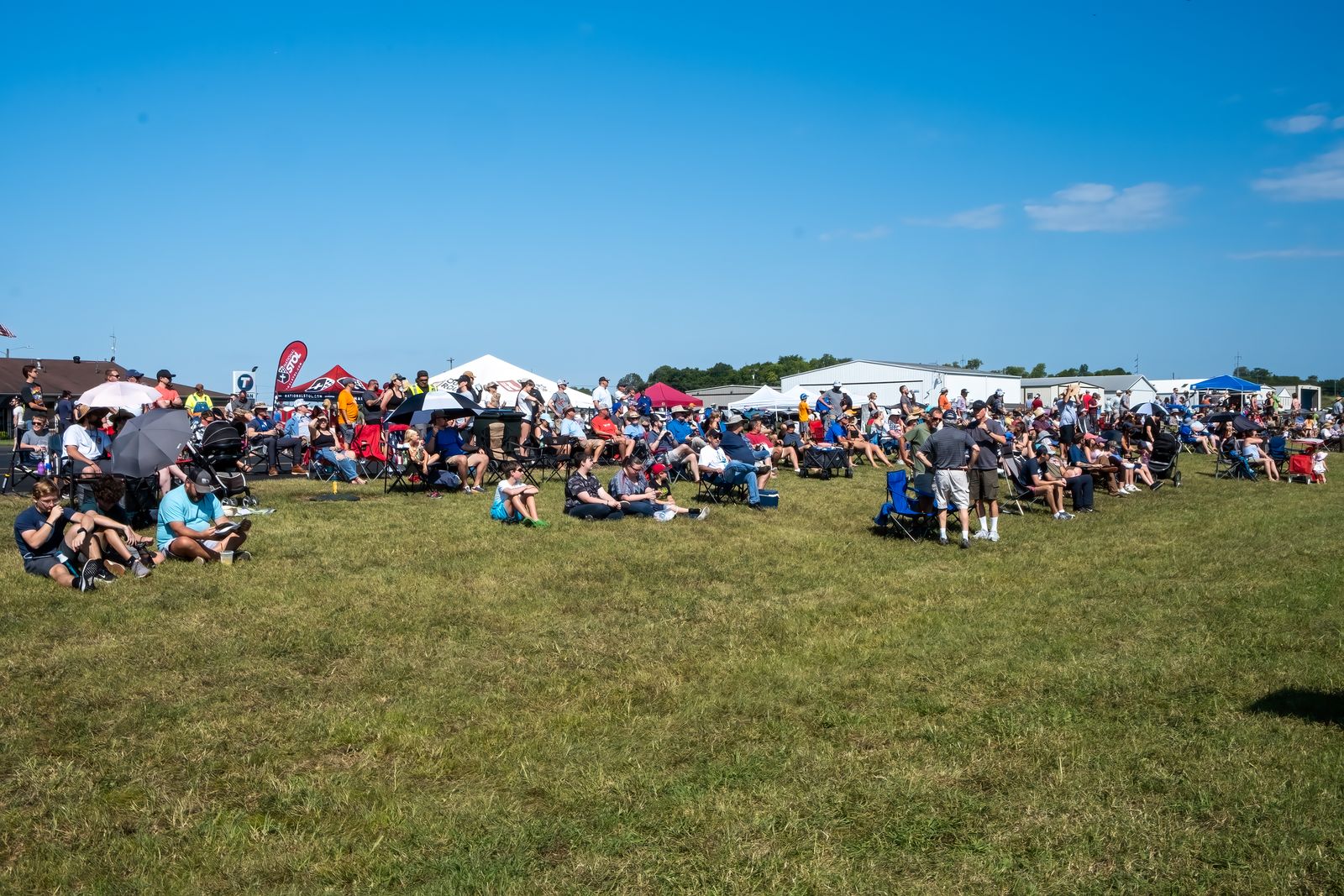 Families spread out on the lawn along the tent line