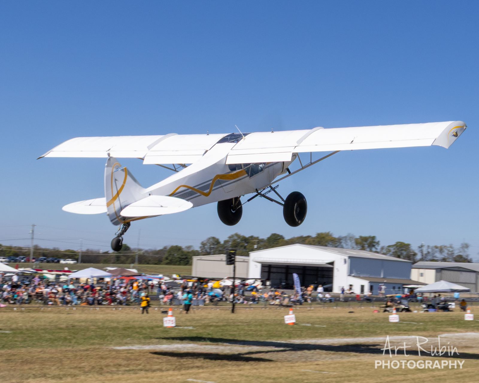 STOL competitor lifting off in front of the packed spectator line