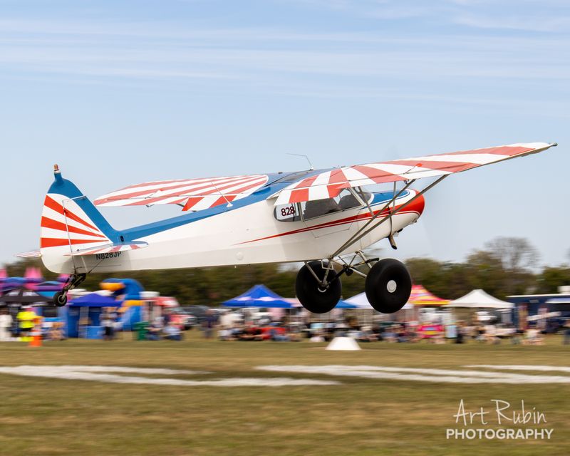 Race 828 · Foster Carney · Piper PA-18 N828JP climbing out over the tents