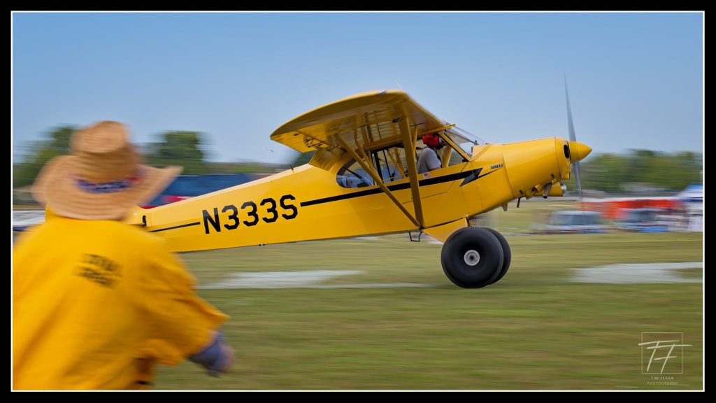 N333S lifting off past a line judge in the yellow volunteer shirt