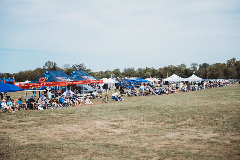 The fan zone: tents, chairs and the crowd along the flight line